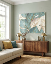 Leaves glass wall art displayed above a walnut credenza in a soft sage-walled living room with cream sofa and brass lamps