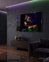 Neon Woman glass wall art displayed above a dark wood credenza in a moody concrete-walled lounge with magenta and green LED accents