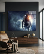 Astronaut glass wall art displayed above a walnut floating credenza in a charcoal-walled lounge with cognac leather armchair and globe