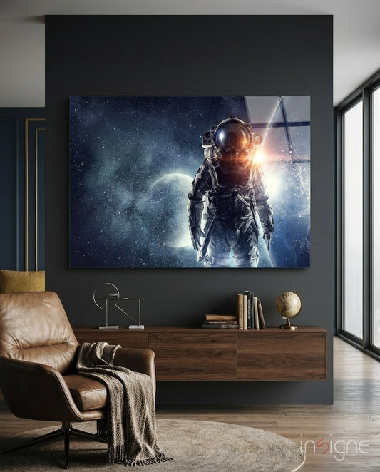 Astronaut glass wall art displayed above a walnut floating credenza in a charcoal-walled lounge with cognac leather armchair and globe