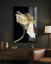 Flower glass wall art displayed above a walnut credenza in a moody charcoal-walled lounge with cognac armchair and dried botanicals