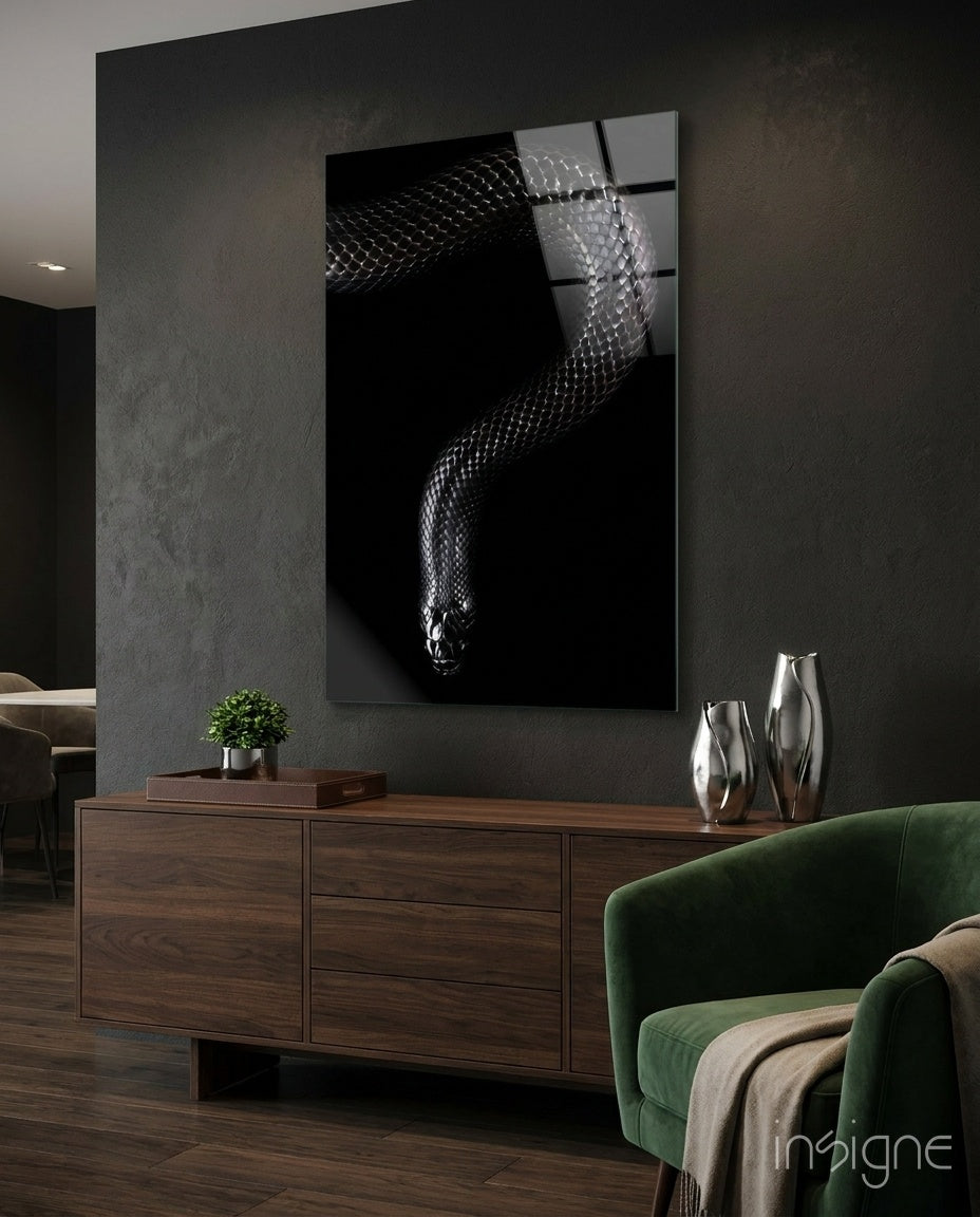 Snake glass wall art displayed above a walnut credenza in a moody charcoal-walled lounge with green velvet armchair and silver vases