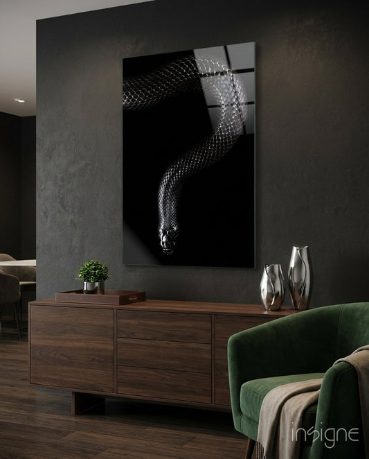 Snake glass wall art displayed above a walnut credenza in a moody charcoal-walled lounge with green velvet armchair and silver vases