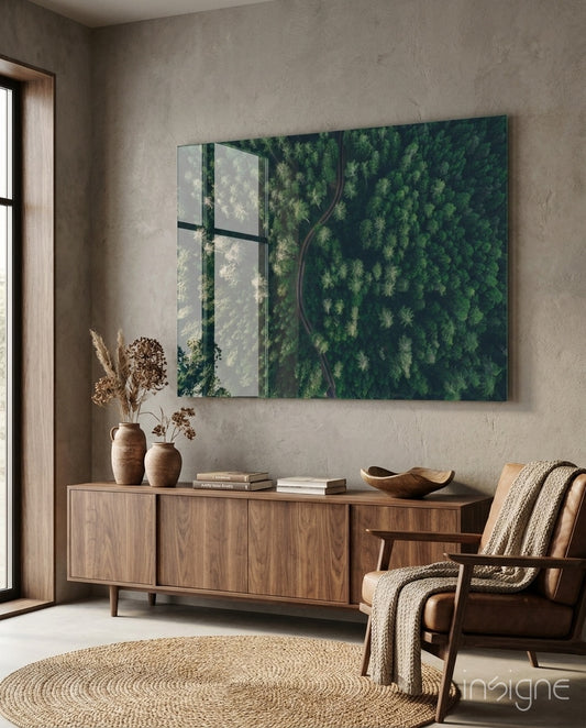 Forest glass wall art displayed above a walnut credenza in a soft taupe-walled lounge with cognac armchair and dried botanical vases