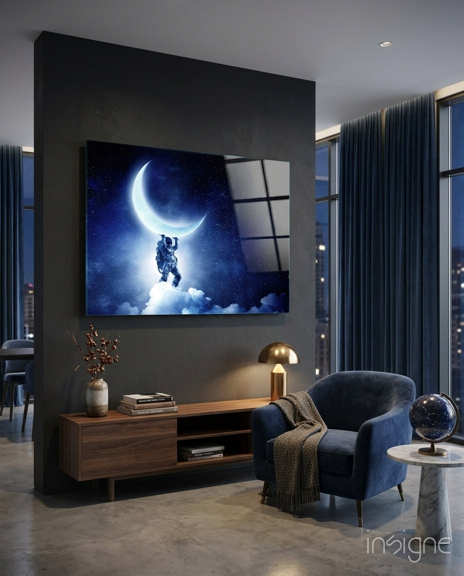 Moon Bearer glass wall art displayed above a walnut credenza in a moody charcoal-walled lounge with navy velvet armchair and constellation globe