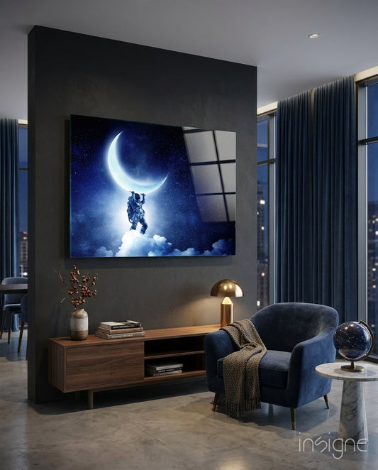 Moon Bearer glass wall art displayed above a walnut credenza in a moody charcoal-walled lounge with navy velvet armchair and constellation globe