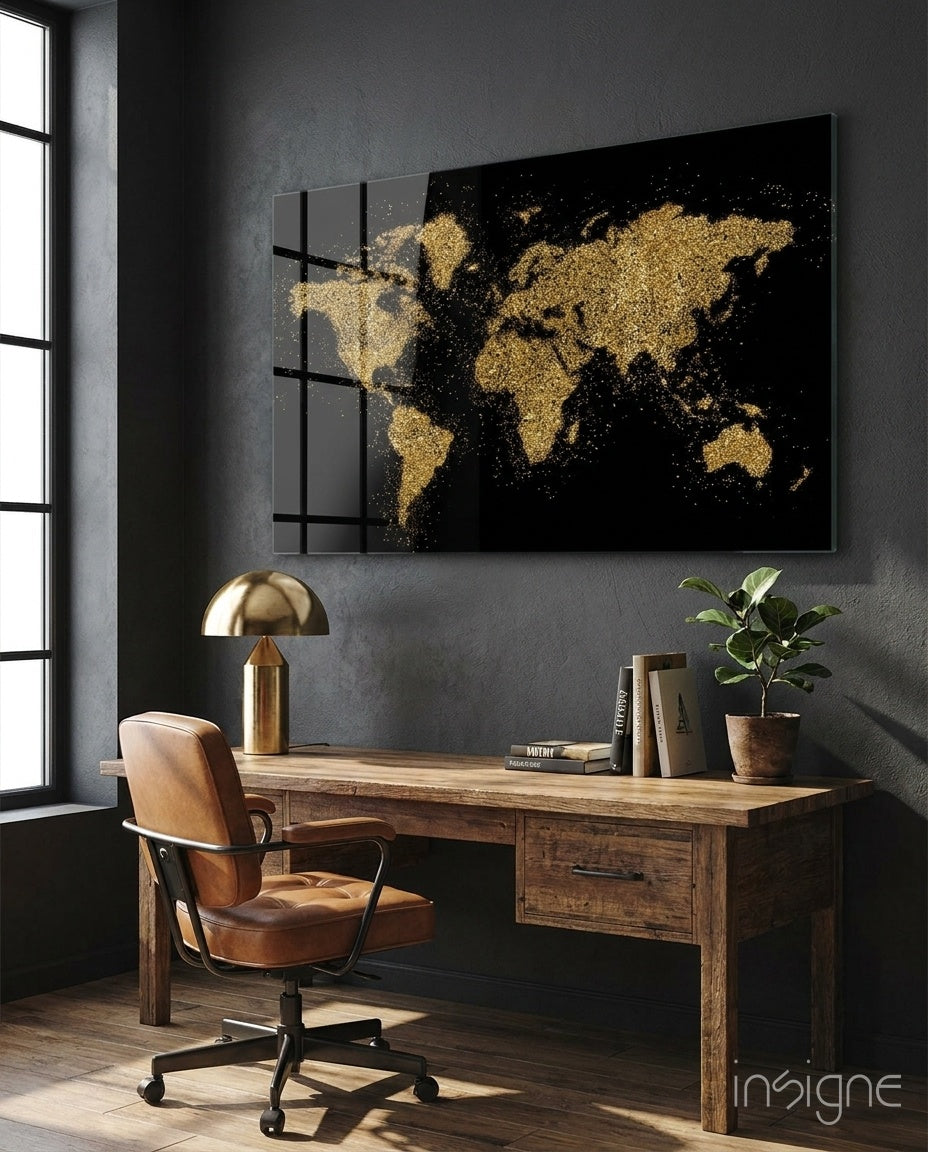World Map glass wall art displayed above a rustic wood desk in a moody charcoal-walled office with cognac leather chair and brass lamp