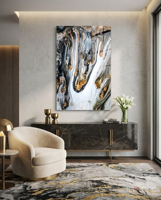 Abstract glass wall art displayed above a black marble credenza in a soft taupe-walled lounge with cream swivel chair and calla lilies