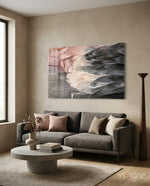 Abstract glass wall art displayed above a charcoal linen sofa in a sand-toned plaster lounge with concrete coffee table and pampas vase