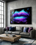 Lip glass wall art displayed above a gray leather sofa in a concrete-walled lounge with violet velvet pillows and reclaimed wood coffee table