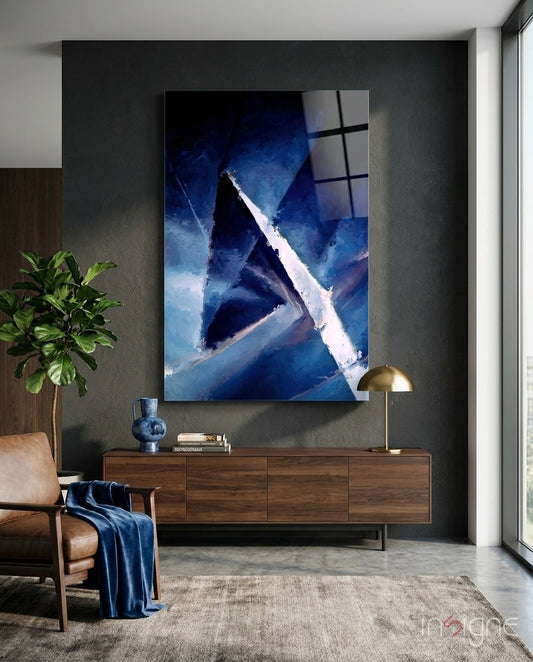 Abstract glass wall art displayed above a walnut credenza in a moody charcoal-walled lounge with cognac armchair and navy throw