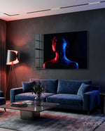 Women's glass wall art displayed above a navy velvet sofa in a moody charcoal-walled lounge with crimson lamp and dark drapes