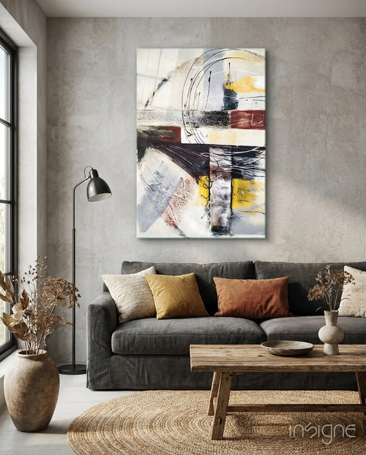 Abstract glass wall art displayed above a charcoal sofa in a concrete-walled lounge with reclaimed wood bench and dried botanicals