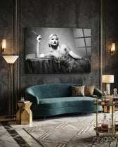 Roaring 20s glass wall art displayed above a teal velvet sofa in a paneled charcoal-walled lounge with brass sconces and marble floor
