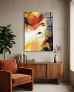 Women's glass wall art displayed above a walnut credenza in a soft taupe-walled lounge with rust velvet armchair and fiddle leaf fig