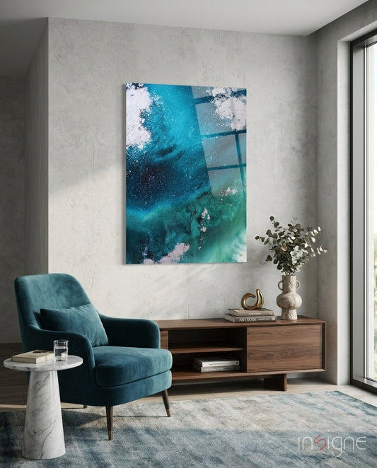 Colors of Abstraction glass wall art displayed above a charcoal sectional in a soft concrete-walled lounge with teal velvet pillows and palm vase