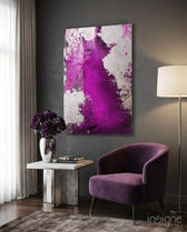 Colors of Abstraction glass wall art displayed beside a plum velvet armchair in a charcoal-walled lounge with marble side table