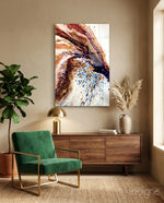 Abstract glass wall art displayed above a walnut credenza in a soft taupe-walled lounge with green velvet armchair and pampas vase