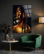Stain glass wall art displayed beside a green velvet armchair in a moody charcoal-walled lounge with marble side table and dried botanicals