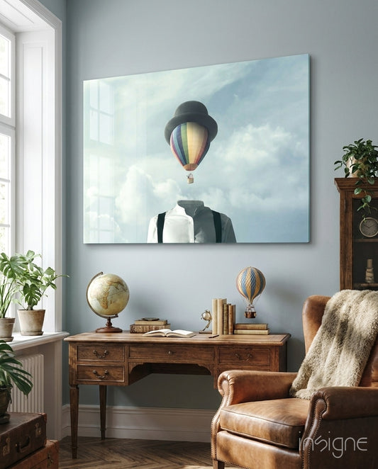 Balloon Heads glass wall art displayed above an antique wood desk in a soft blue-walled study with leather wing chair and antique globe