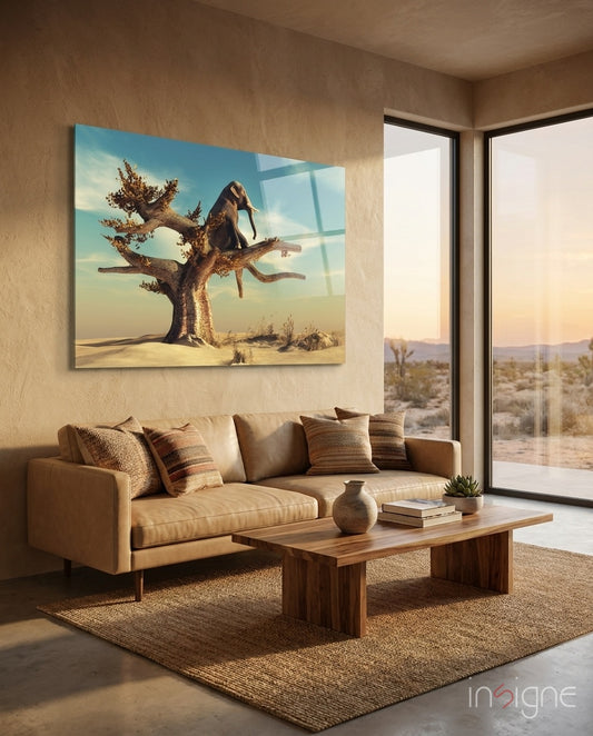 Thinking Elephant glass wall art displayed above a tan leather sofa in a soft sand-plaster lounge with reclaimed wood coffee table and desert view