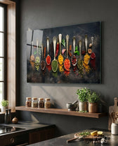 Spices glass wall art displayed above a wood floating shelf in a warm charcoal-walled kitchen with potted herbs and stone counter