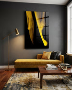 Yellow Story glass wall art displayed above a saffron velvet daybed in a charcoal-walled lounge with brass floor lamp and walnut coffee table