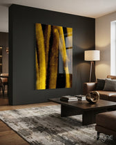 Yellow Story glass wall art displayed above a dark wood coffee table in a moody charcoal-walled lounge with cognac sectional and tripod lamp