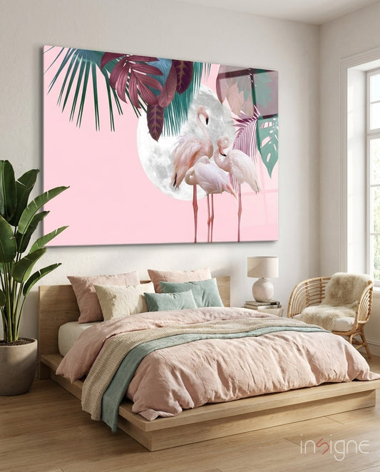 Flamingo glass wall art displayed above a wood platform bed in a soft pink-walled bedroom with rattan armchair and traveler palm