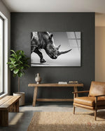 Black Rhino glass wall art displayed above a rustic wood console in a moody charcoal-walled hallway with cognac armchair and fiddle leaf fig