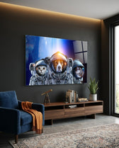 Space Team glass wall art displayed above a walnut credenza in a charcoal-walled lounge with navy velvet armchair and brass telescope