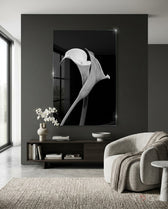 Flower glass wall art displayed above a dark wood credenza in a moody charcoal-walled lounge with bouclé swivel chair and orchid arrangement