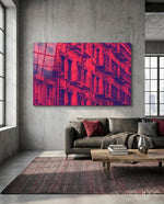 Windows glass wall art displayed above a charcoal leather sectional in a concrete-walled industrial lounge with reclaimed wood coffee table and crimson pillows