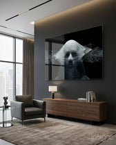Self glass wall art displayed above a walnut credenza in a moody charcoal-walled lounge with leather armchair and city view