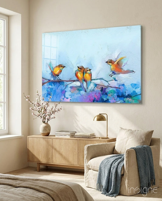 Tiny Birds glass wall art displayed above a wood credenza in a soft cream-plaster bedroom with linen armchair and almond branch arrangement