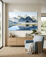 Mountains glass wall art displayed above a wood credenza in a soft cream-plaster lounge with pale blue armchair and bonsai