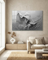 Relief Woman glass wall art displayed above a wood credenza in a soft cream-plaster lounge with cream linen sofa and pampas vase