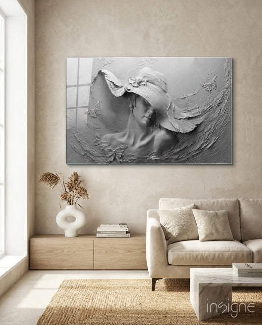 Relief Woman glass wall art displayed above a wood credenza in a soft cream-plaster lounge with cream linen sofa and pampas vase