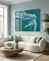 Storm in Thoughts glass wall art displayed above a bouclé curved sofa in a soft pale-blue lounge with sage velvet pillows and round wood coffee table