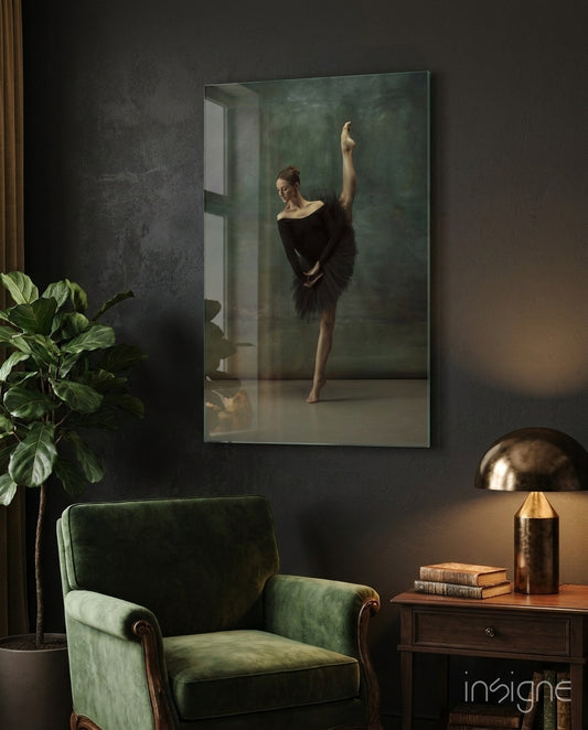 Ballerina glass wall art displayed beside a green velvet armchair in a moody charcoal-walled study with brass desk lamp and antique books
