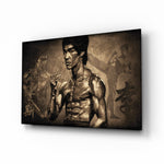 Bruce Lee glass wall art displayed above a leather chesterfield in a moody man cave with reclaimed-wood console and brass arc lamp