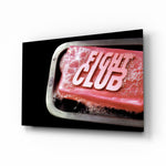 Fight Club glass wall art displayed above a black leather sectional in a moody man cave with brass arc lamp and reclaimed-wood console