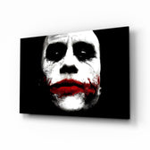 Joker glass wall art displayed above a black leather sectional in a moody home theater with brass arc lamp and reclaimed-wood console
