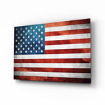 Flag of the United States glass wall art displayed above a leather chesterfield in an Americana lounge with reclaimed-wood console and brass picture light