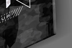 Close-up detail of the blue and silver camo typography behind glass