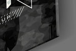 Close-up detail of the gold and silver camo typography behind glass