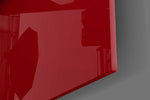 Close-up detail of the gold-bronze S on red marbled surface behind glass