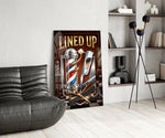 lined up vintage barbershop emblem glass wall art leaning beside a dark leather sofa
