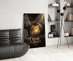 gold vintage camera with a sunrise lens glass wall art leaning beside a dark leather sofa