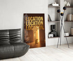 gold real estate key with a skyline glass wall art leaning beside a dark leather sofa